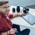 Happy freelancer man sitting by working table with graphic tablet